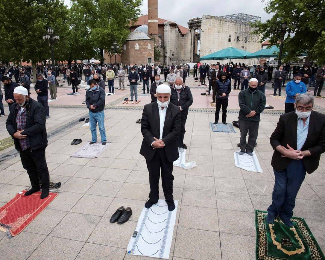 People, wearing face masks and observing social distancing guidelines to protect against coronavirus, attend Friday prayers, outside historical Haci Bayram Mosque, in Ankara, Turkey, Friday, May 29, 2020. Worshippers in Turkey have held their first communal Friday prayers in 74 days after the government re-opened some mosques as part of its plans to relax measures in place to fight the coronavirus outbreak. Prayers were held in the courtyards of a select number of mosques on Friday, to minimize the risk of infection.