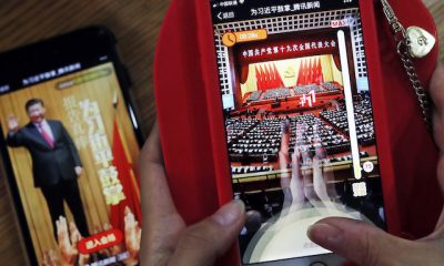 A woman poses as she playing a Tencent's smartphone game called "A Great Speech, clap for Xi Jinping" in Beijing, Friday, Oct. 20, 2017. Ordinary young Chinese may not have paid close attention to Xi Jinping's 3-and-a-half hour marathon speech this week, but they're happy to "applaud" the president in …