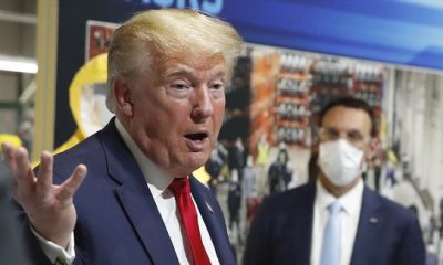 In this May 21, 2020 photo, President Donald Trump holds a face mask in his left hand as speaks during a tour of Ford's Rawsonville Components Plant that has been converted to making personal protection and medical equipment in Ypsilanti, Mich.