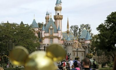 FILE - In this Jan. 22, 2015, file photo, visitors walk toward Sleeping Beauty's Castle in the background at Disneyland Resort in Anaheim, Calif. Disneyland says it's closing its California parks starting Saturday over coronavirus concerns. For most people, the new coronavirus causes only mild or moderate symptoms. For some …