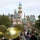 FILE - In this Jan. 22, 2015, file photo, visitors walk toward Sleeping Beauty's Castle in the background at Disneyland Resort in Anaheim, Calif. Disneyland says it's closing its California parks starting Saturday over coronavirus concerns. For most people, the new coronavirus causes only mild or moderate symptoms. For some …
