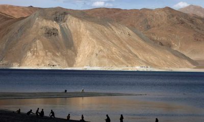 In this July 22, 2011 file photo, people stand by the banks of the Pangong Lake, near the India-China border in Ladakh, India.Indian officials say Indian and Chinese soldiers are in a bitter standoff in the remote and picturesque Ladakh region, with the two countries amassing soldiers and machinery near the tense frontier. The officials said the standoff began in early May when large contingents of Chinese soldiers entered deep inside Indian-controlled territory at three places in Ladakh, erecting tents and posts.