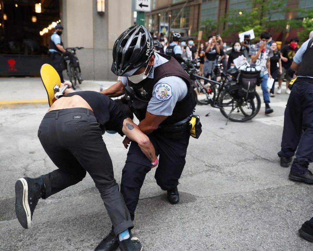 An officer takes down a protester after breaking through a police barrier during a march to bring attention to the death of George Floyd in the Loop Friday, May 29, 2020, in Chicago. Floyd died after being restrained by Minneapolis police officers on Memorial Day. (John J.