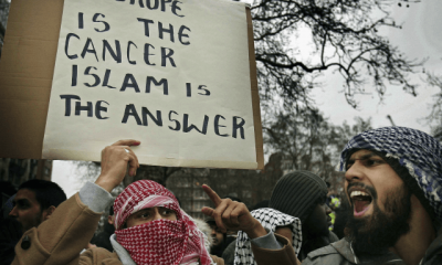 LONDON - FEBRUARY 03: Muslim demonstrators hold banners at the Danish Embassy on February 3, 2006 in London. British muslims have condemned newspaper cartoons which first appeared in a Danish newspaper, some of which depict the Prophet Mohammed wearing a turban shaped like a bomb. The cartoons have sparked worldwide …