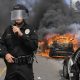 Police commander Cory Palka stands among several destroyed police cars as one explodes while on fire during a protest over the death of George Floyd in Los Angeles on Saturday. Floyd died in police custody on Memorial Day in Minneapolis.