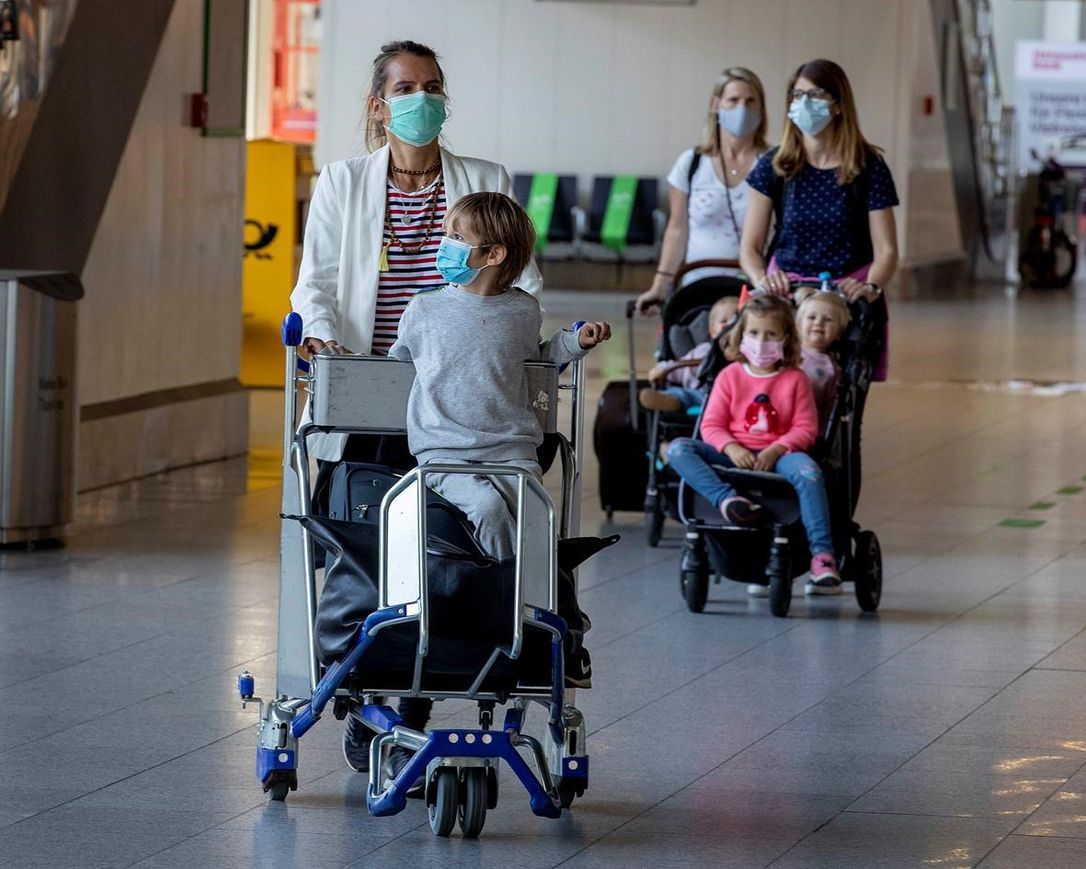 Wives and children of German business men working in China walk through a terminal at the airport in Frankfurt, Germany, Friday, May 29, 2020. Together with 200 others they are about to take a flight to Tianjin in China. After a coronavirus test in the morning in Frankfurt they expect a two week quarantine in China.