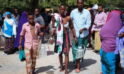 A wounded man is helped as he arrives at Madina hospital after being injured when an explosive device ripped through a minibus on the outskirts of Mogadishu on Sunday.
