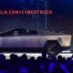 Tesla co-founder and CEO Elon Musk on stage with  the newly unveiled all-electric battery-powered Tesla Cybertruck with broken g