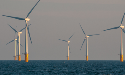 An offshore windfarm in a dark sea with seven turbines visible in the photograph.