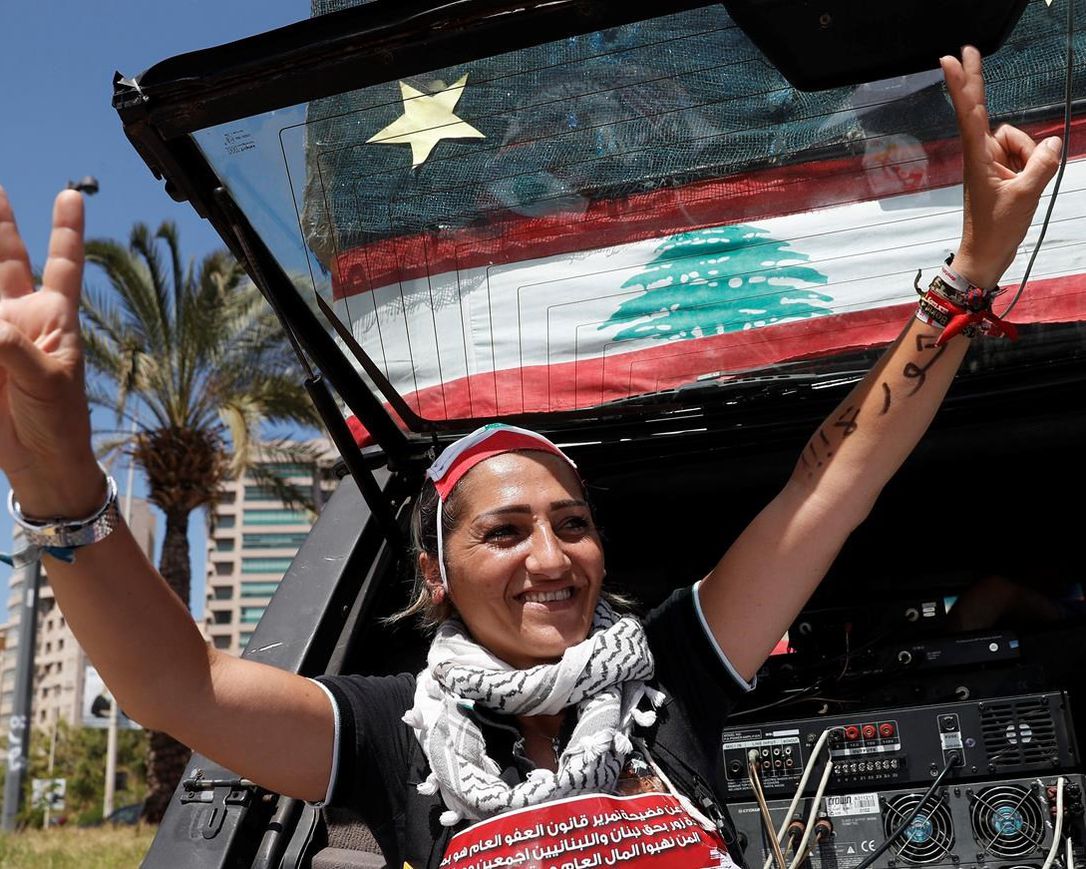 An anti-government protester flashes victory signs during a protest against a general amnesty law being proposed in parliament, in Beirut, Lebanon, Thursday, May 28, 2020.