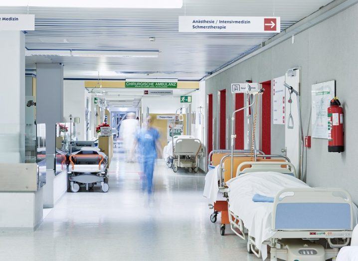 Busy hospital corridor lined with beds.