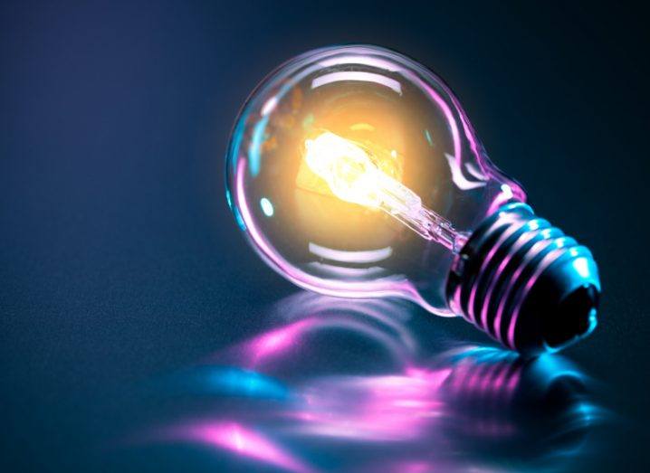 A light bulb shining against a blue and purple background.