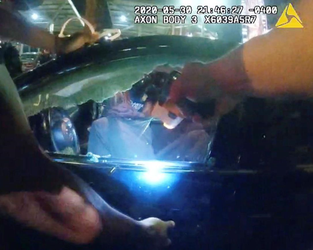 In this Saturday, May 30, 2020, photo taken from police body camera video released by the Atlanta Police Department, an officer points his handgun at Messiah Young while the college student is seated in his vehicle, in Atlanta. The following day, Atlanta's mayor two police officers were fired and three others placed on desk duty over excessive use of force during the arrest of Young and fellow college student Taniyah Pilgrim, seated in the passenger side of the car.