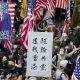 In this Dec. 1, 2019, file photo, protesters wave United States flags and a banner with the words "Chase away Communists and return my Hong Kong" during a rally march towards the U.S. consulate in Hong Kong.