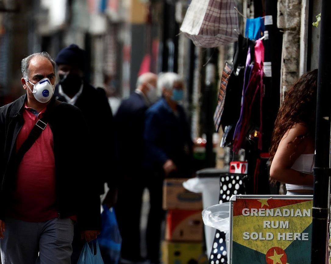 Customers stroll through Shepherd's bush market that is allowed to reopen after the COVID-19 lockdown in London, Monday, June 1, 2020. The British government has lifted some lockdown restrictions to restart social life and activate the economy while still endeavouring to limit the spread of the highly contagious COVID-19 coronavirus.
