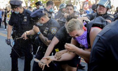 New York Police officers use pepper spray on protesters during a demonstration on Saturday in the Brooklyn borough of New York. The fourth day of protests against police brutality kept the city on edge as thousands of people marched and many protesters and officers tried to keep the peace.