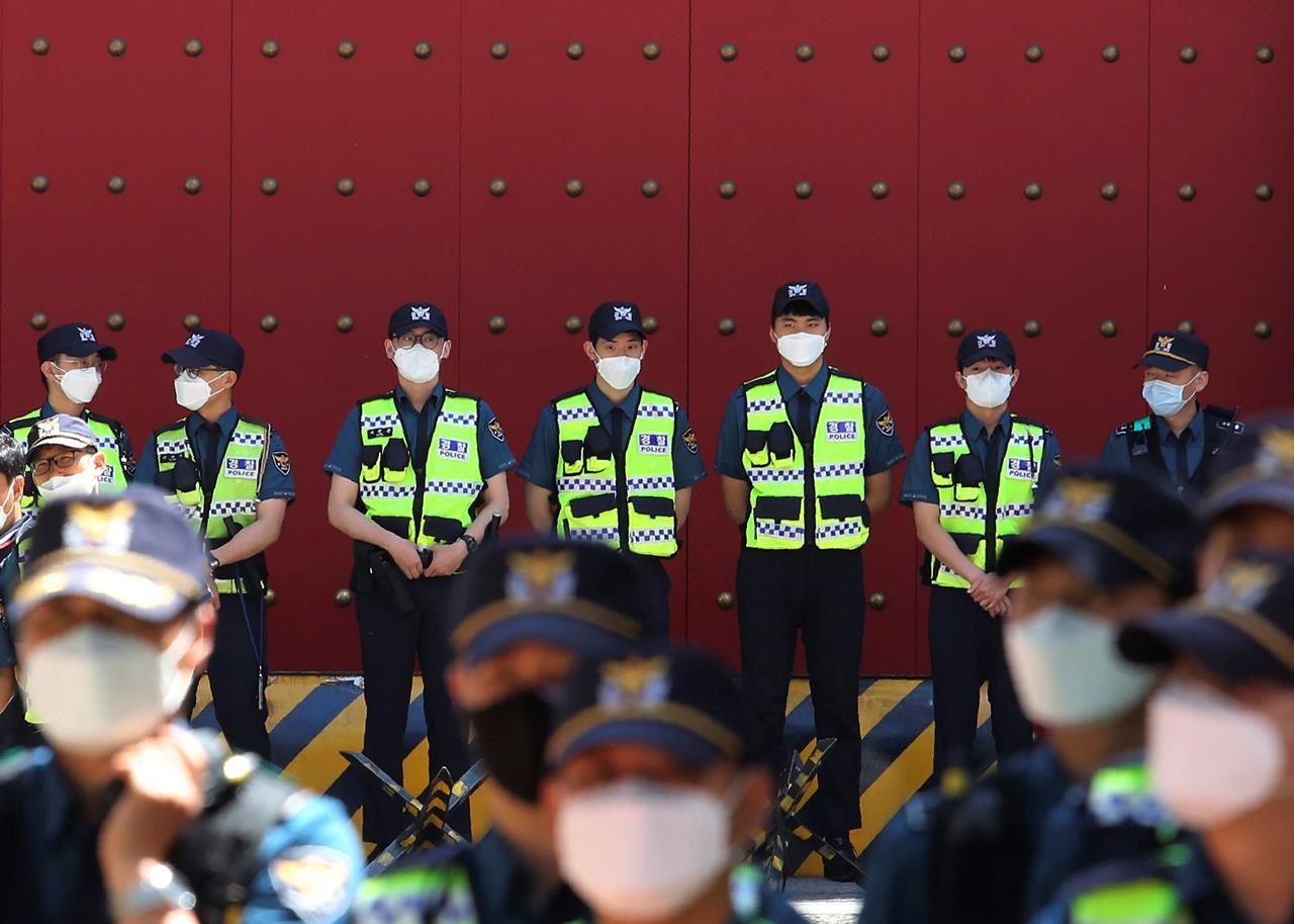 Police officers wearing face masks to help protect against the spread of the new coronavirus stand guard in front of the Chinese embassy in Seoul, South Korea, Monday, June 1, 2020.