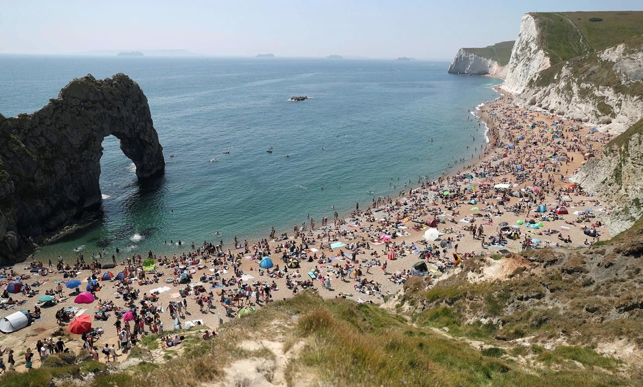 People on the beach at Durdle Door, as the public are being reminded to practice social distancing following the relaxation of coronavirus lockdown restrictions, near Lulworth in Dorset, England, on Saturday.