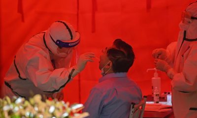 A medical worker takes a swab sample from a man to test for the COVID-19 coronavirus in Wuhan, in Chinas central Hubei province on May 19. Wuhan is set to complete the testing of its entire population of 11 million as China pours massive resources into avoiding a resurgence of COVID-19 infections.
