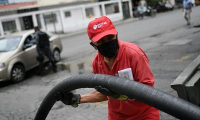 A worker wearing a face mask amid the new coronavirus pandemic works to fills up one of the tanks of a state oil company gas station in Caracas, Venezuela, Sunday, May 31, 2020. After decades of being the cheapest gasoline in the world, Venezuelan President Nicolas Maduro indicates that as of next Monday a new pricing scheme will be imposed on some 200 stations.
