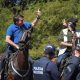 Brazil's President Jair Bolsonaro rides a horse greeting supporters outside the presidential palace in Brasilia, Brazil, Sunday, May 31, 2020. Bolsonaro mounted a horse from police that were guarding supporters of his government gathered outside the Planalto Palace.