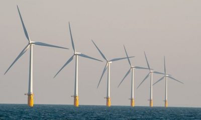 Six offshore wind turbines in a row.
