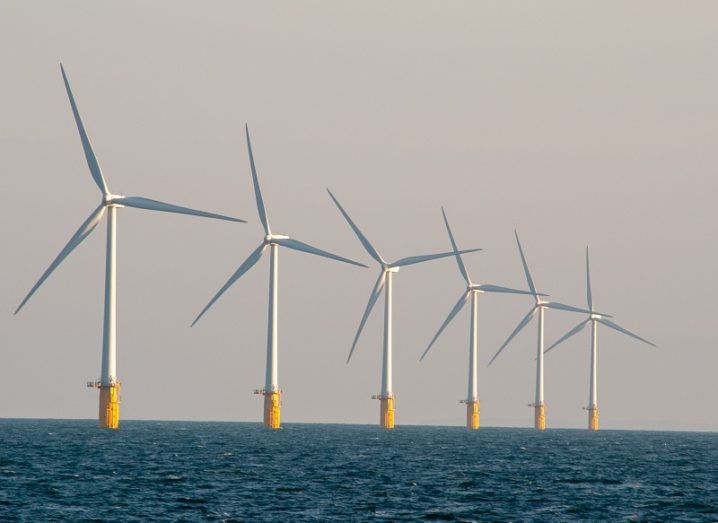 Six offshore wind turbines in a row.