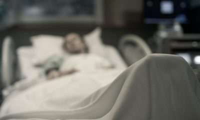 Blurred image of a woman in a hospital bed.