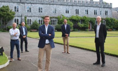 A group of researchers from SeqBiome are standing in the grounds of University College Cork and smiling into the camera.