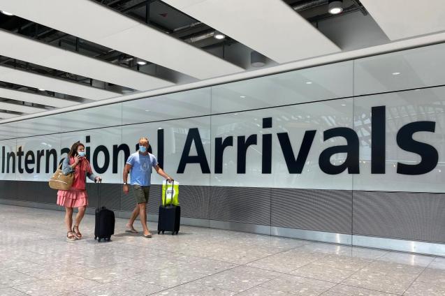 Passengers from international flights arrive at Heathrow Airport